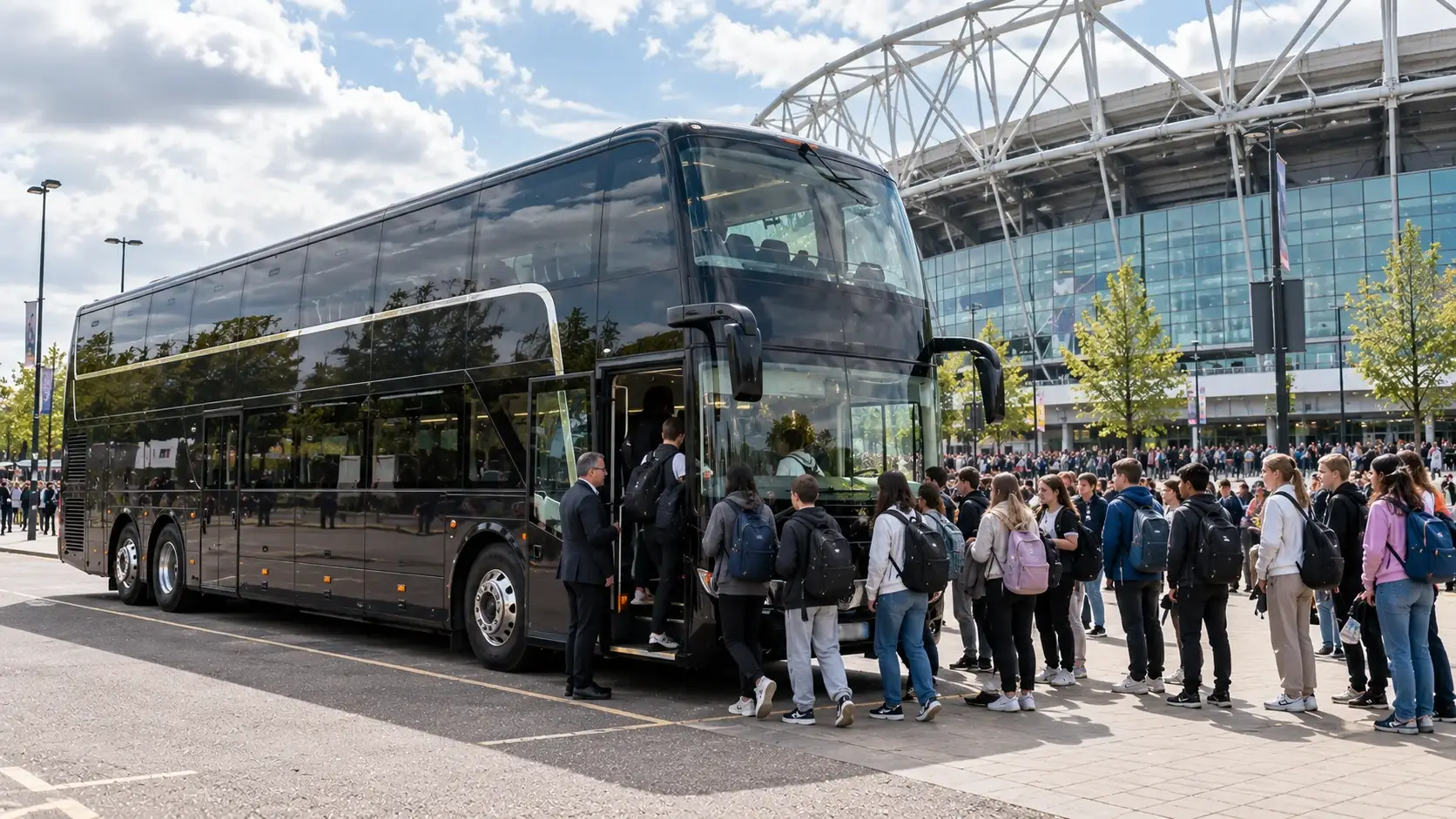 Black double-decker touring coach with a large group queuing to board